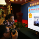 A journalist takes pictures of a screen displaying a court's microblog page showing disgraced Chinese politician Bo Xilai standing trial inside the court, in Jinan, Shandong province August 22, 2013. Bo appeared in public for the first time in more than a year on Thursday to face trial in eastern China, the final chapter of the country's most politically charged case in more than three decades. REUTERS/Carlos Barria